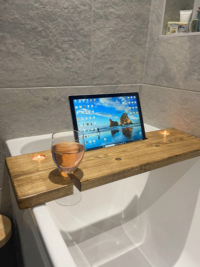 bath caddy holding a glass and a tablet